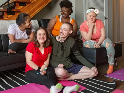 Five people sitting together smiling and talking.
