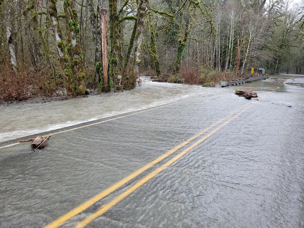 Water running over the road from Mill Creek. The creek runs at road level right along the highway.
